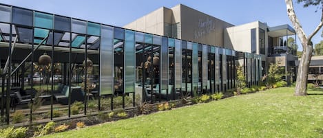 A modern building with a glass facade, outdoor seating, and a sign reading "Dingey International."