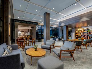 A spacious lobby with modern furniture, a central round table, and a large bookshelf. - Mercure Jakarta Sabang (Jakarta)