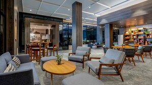 A spacious lobby with modern furniture, a central round table, and a large bookshelf. - Mercure Jakarta Sabang (Jakarta)