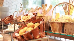 Ett bageridisplay med olika sorters bröd och bakverk i korgar av rotting.