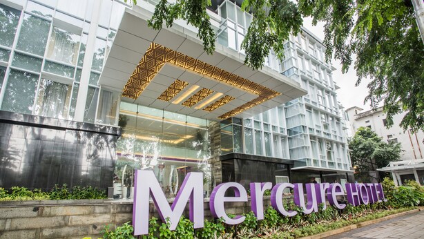 En modern byggnad med en stor skylt där det står ”Mercure Hotel”.