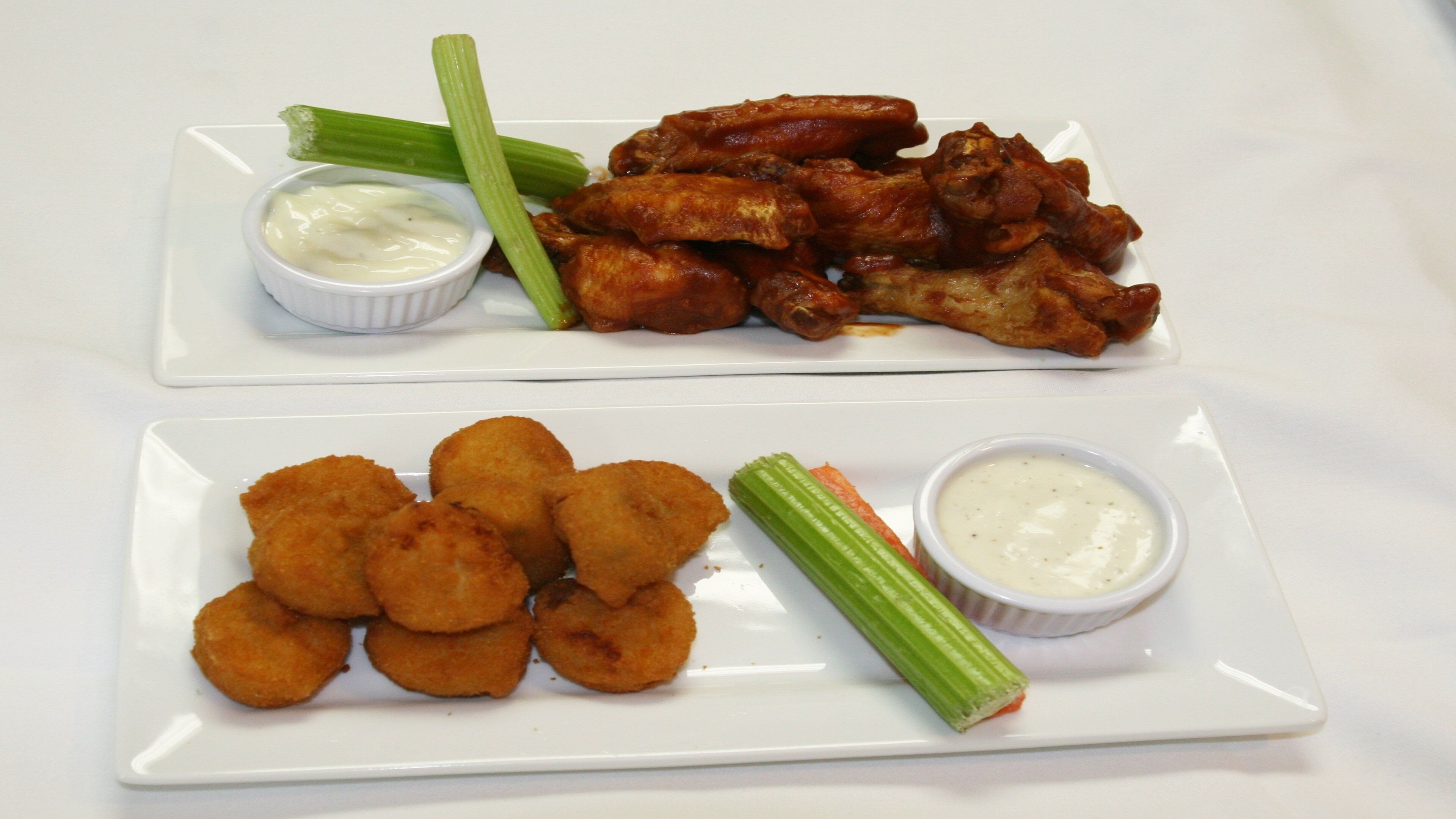 Two rectangular white plates with food items.