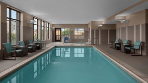 A swimming pool with lounge chairs and a door leading outside. - Residence Inn Salt Lake City Murray (Murray)