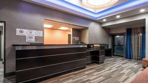 A reception desk with a check-in/out sign, a fitness center notice, and a modern interior design. - Super 8 by Wyndham San Antonio Near Fort Sam Houston (San Antonio)