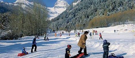 A snowy landscape with people skiing and snowboarding.