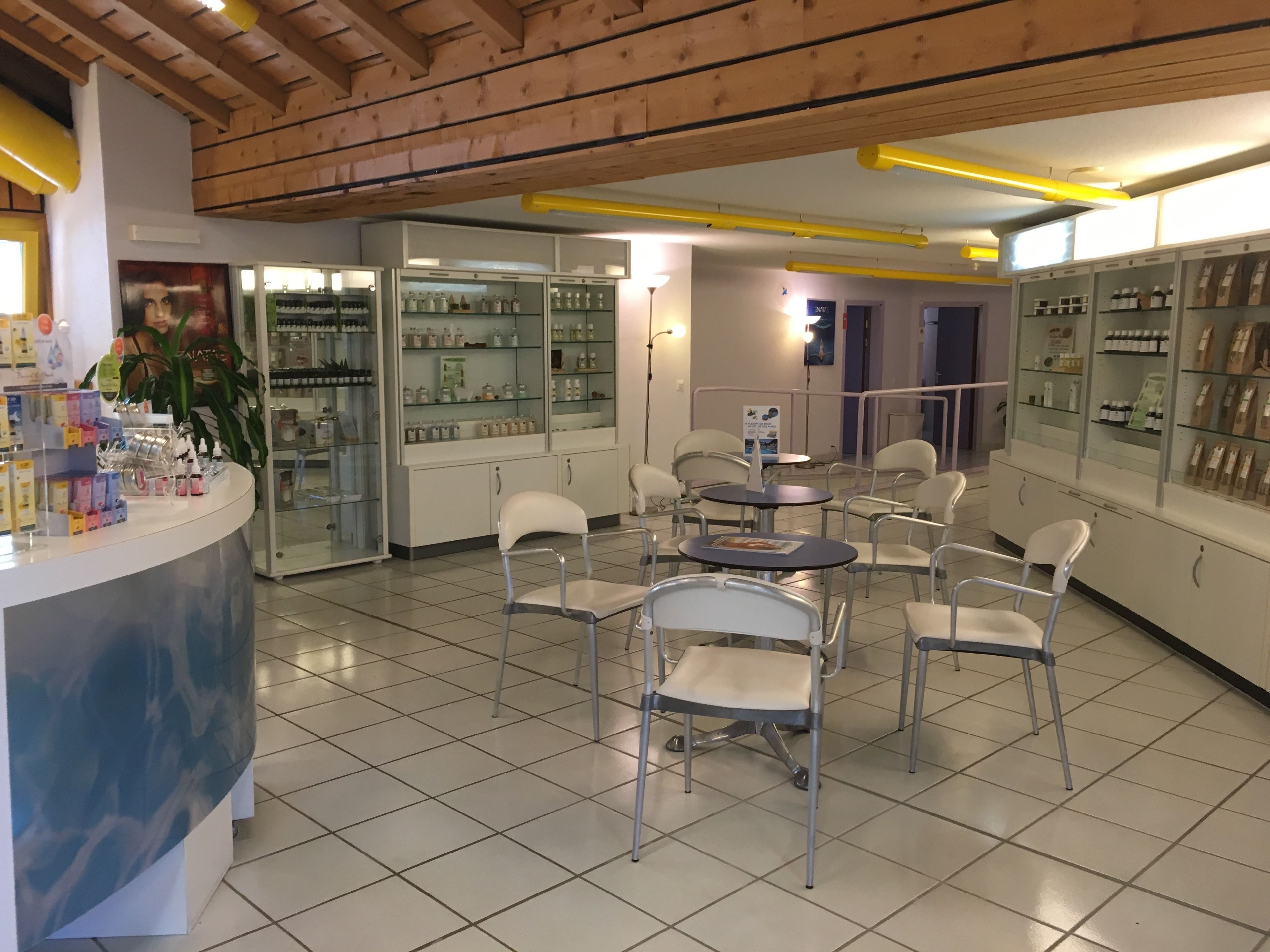 Una cafetería con mostrador, sillas y estanterías llenas de productos.