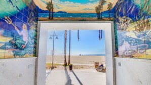 A view through a doorway with a tiled mural depicting a beach scene. - Venice Suites (Venice)