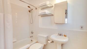 A modern bathroom with a bathtub, toilet, and sink.