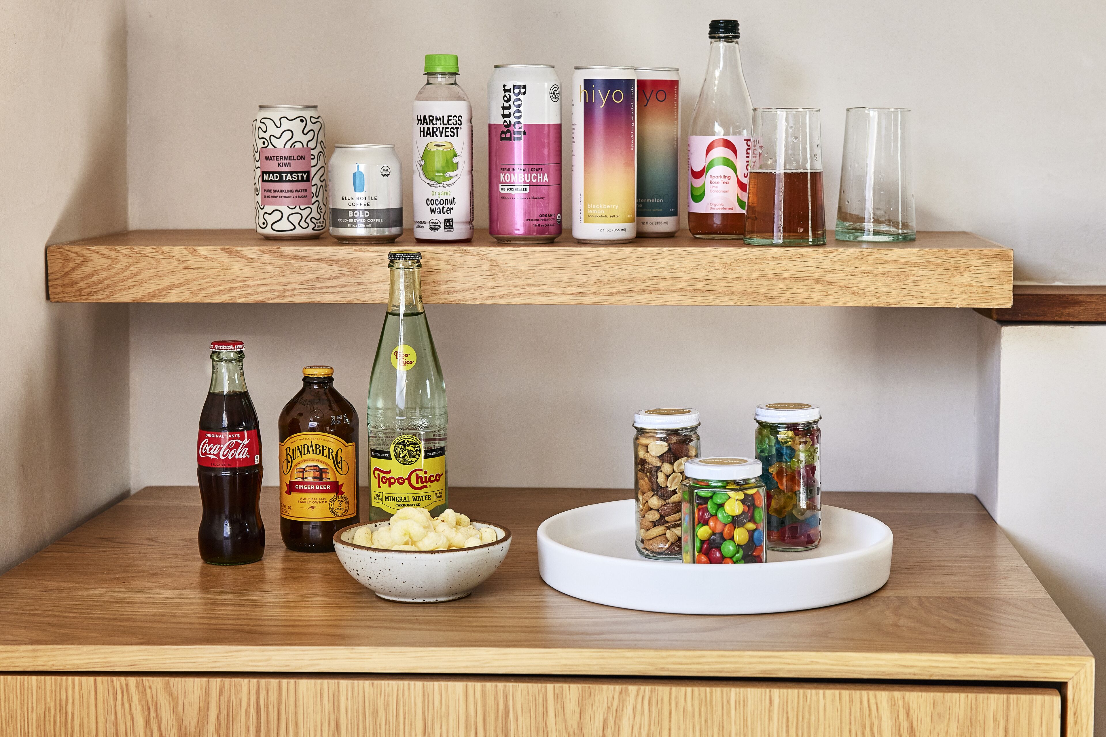 A wooden shelf with various beverages and snacks.