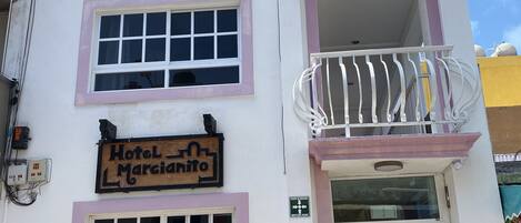 A multi-story building with a sign reading "Hotel Marciatito".