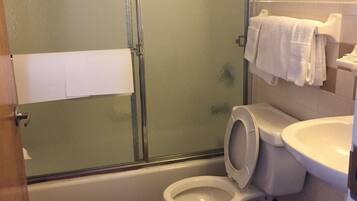 A bathroom with a glass-enclosed shower, a toilet, and a sink.