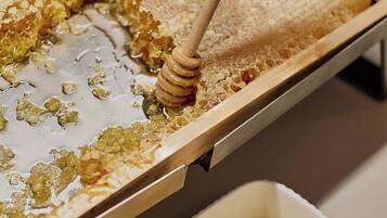 A honeycomb with honeycomb pieces and a honey dipper.