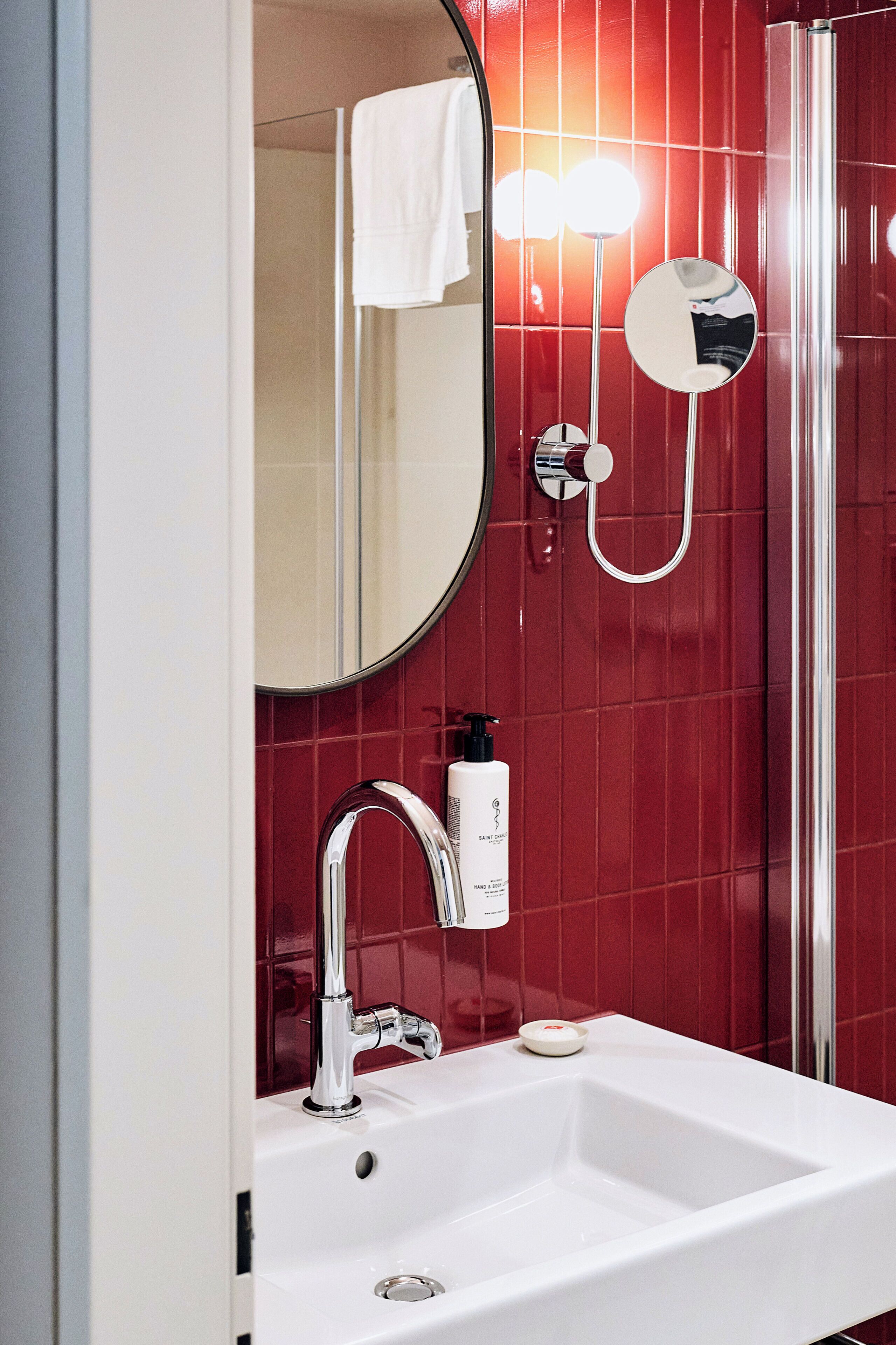 A bathroom with a white sink, chrome faucet, and a handheld showerhead.