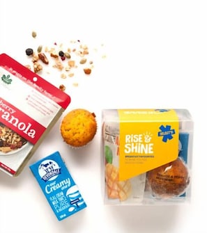 Enjoy a delicious breakfast spread featuring fresh granola, muffins, and Rise & Shine breakfast sandwiches.
