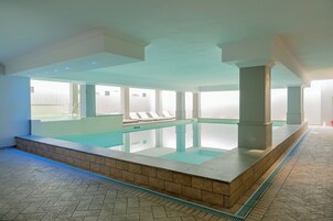 Una piscina cubierta, una piscina al aire libre de temporada, sombrillas