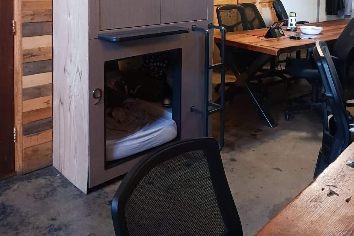 A compact, modern room with a built-in kitchenette, a small seating area, and a dining table.
