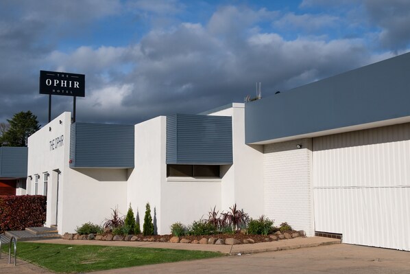 Un bâtiment d’hôtel moderne, sur lequel on peut lire l’inscription « Theophir Hotel ».