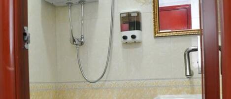 A small bathroom with a toilet, a sink, and a shower.