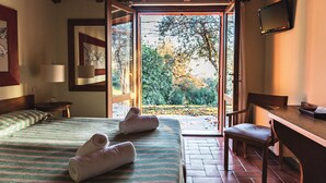 A hotel room with a bed, two towels, a desk, and a TV. - Corte San Mattia - Agriturismo in Verona (Verona)