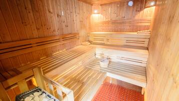A sauna with wooden benches and a small sink.