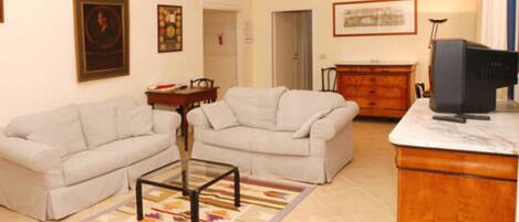 A living room with two sofas, a coffee table, a TV, and a dresser.