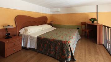 Una camera da letto con un letto di legno, un comodino, una scrivania e una sedia.