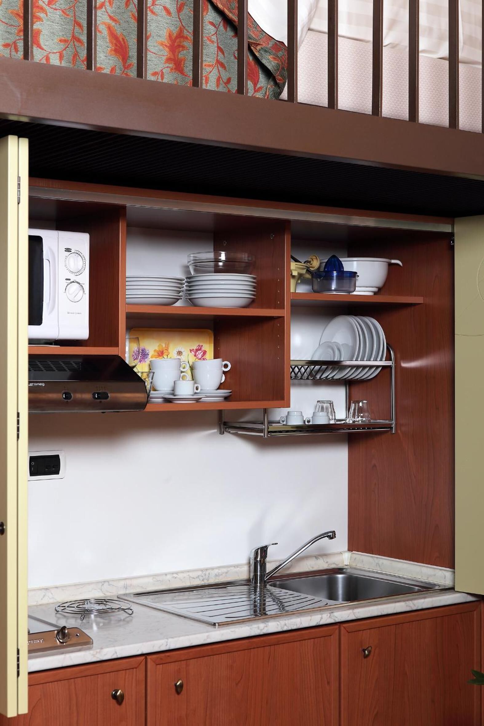 A compact kitchen with a built-in microwave, stove, and sink.