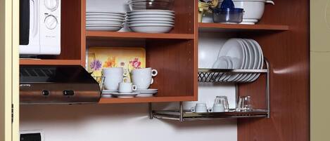 A compact kitchen with a built-in microwave, stove, and sink.