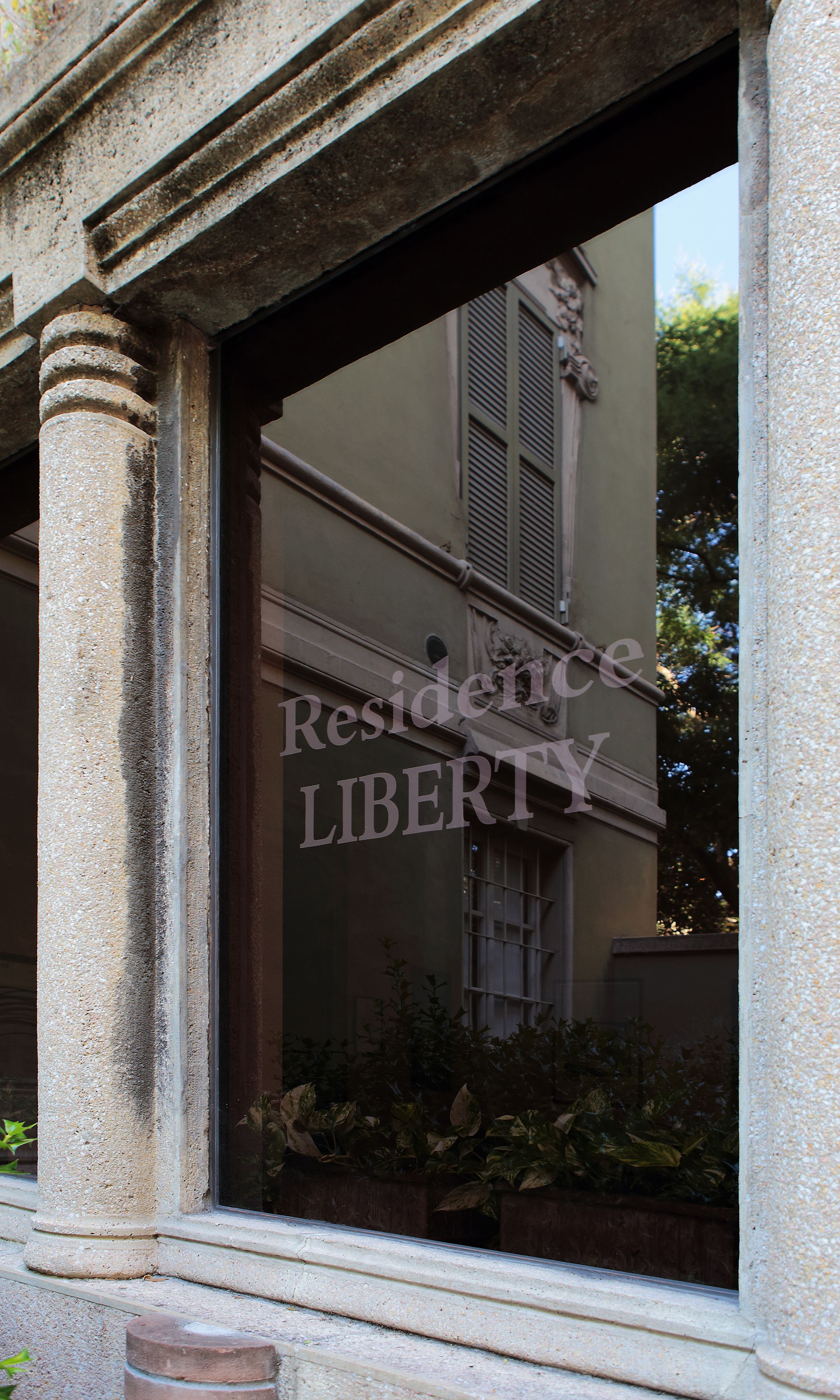 A building entrance with a window displaying the words "Residence Liberty".