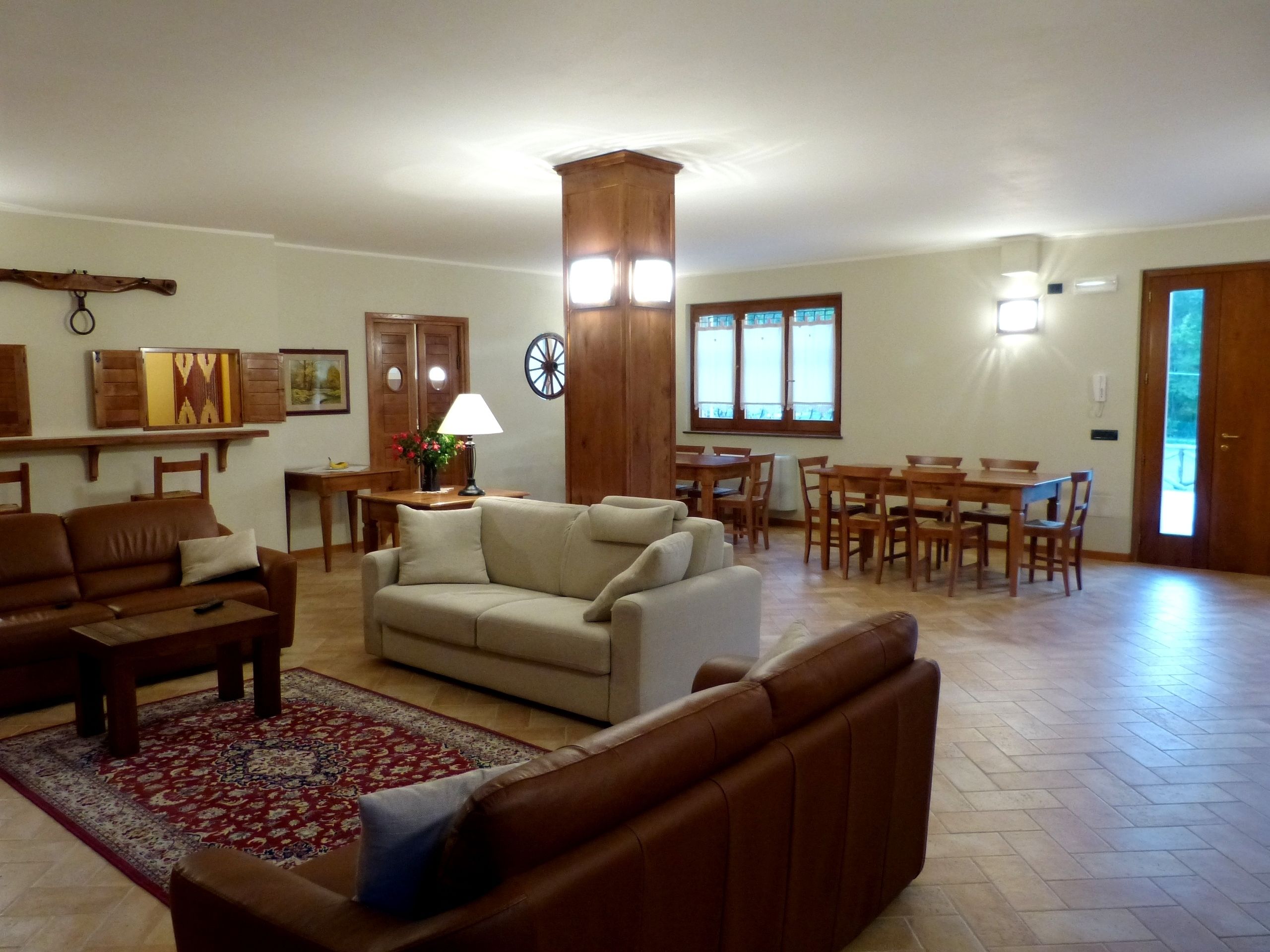 A spacious living room with a large sofa, a coffee table, and a dining area with a table and chairs.