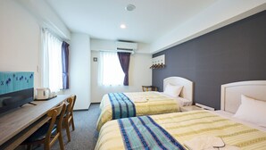 A hotel room with two beds, a desk with a computer, and a TV. - Hotel Peace Island Naha (Naha)