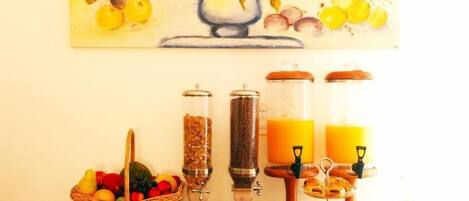 Ein Frühstücksbuffet mit verschiedenen Speisen, darunter Obst, Gebäck und Getränke.