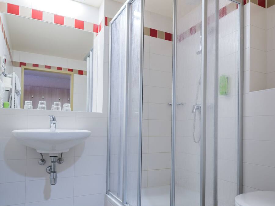 Ein Badezimmer mit Duschkabine, Waschbecken und Toilette.