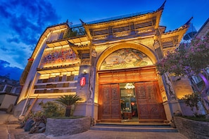 A traditional building with a large entrance, a balcony with a railing, and a sign with Chinese characters. - China Old Story Inns Dali Ancient Town (Dali)