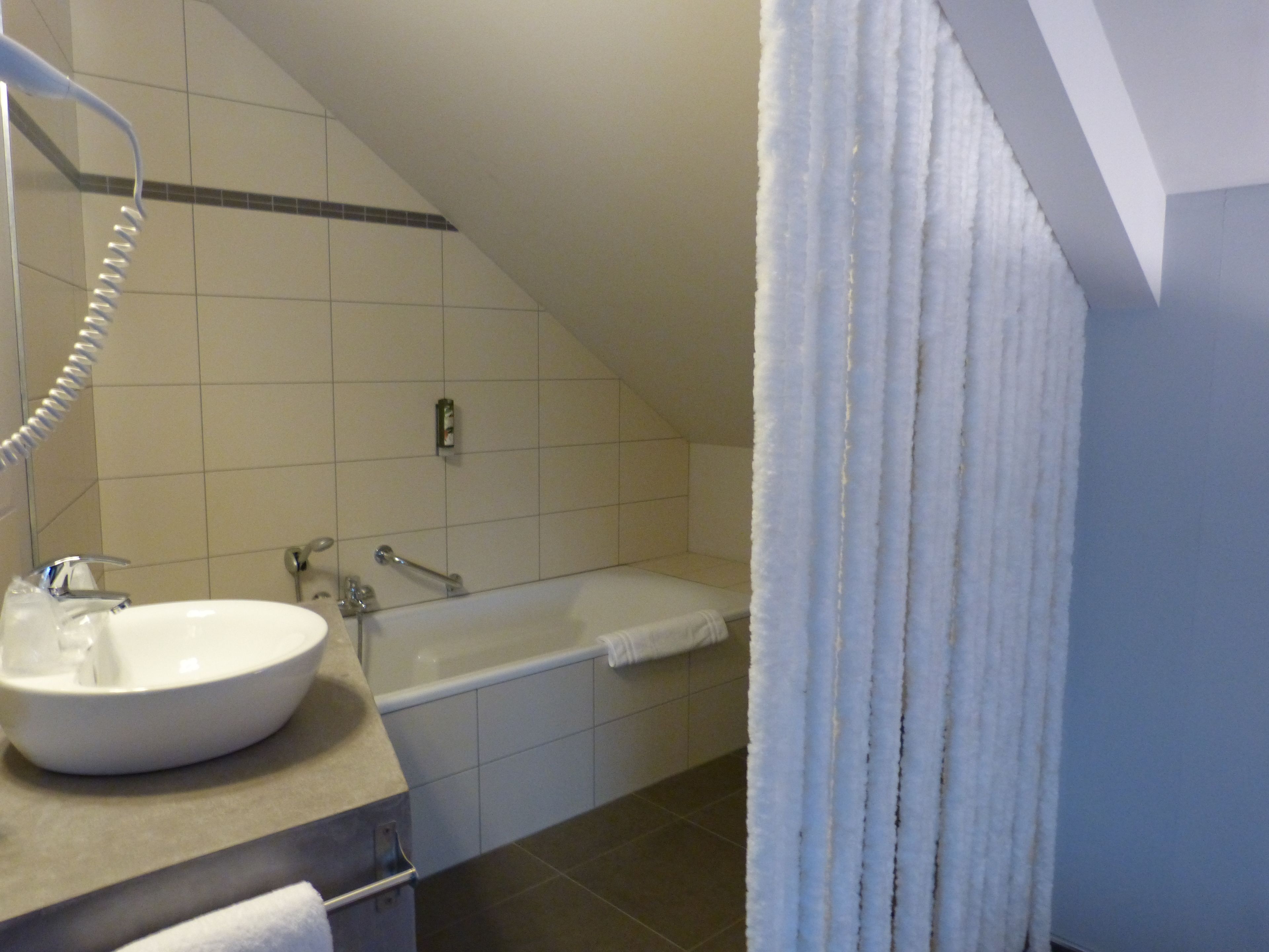 A bathroom with a white sink, a bathtub, and a shower.