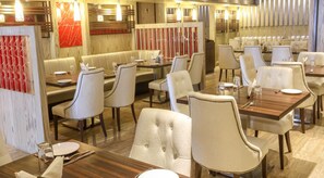 Um restaurante com cabines e mesas, piso de madeira e decoração moderna.