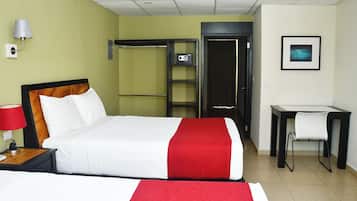 Een hotelkamer met een bed, een bureau, een stoel, een kledingkast en een foto aan de muur.