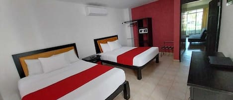 Een hotelkamer met twee bedden, een bureau en een televisie.