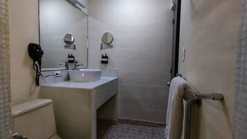 A compact bathroom with a toilet, sink, and mirror.
