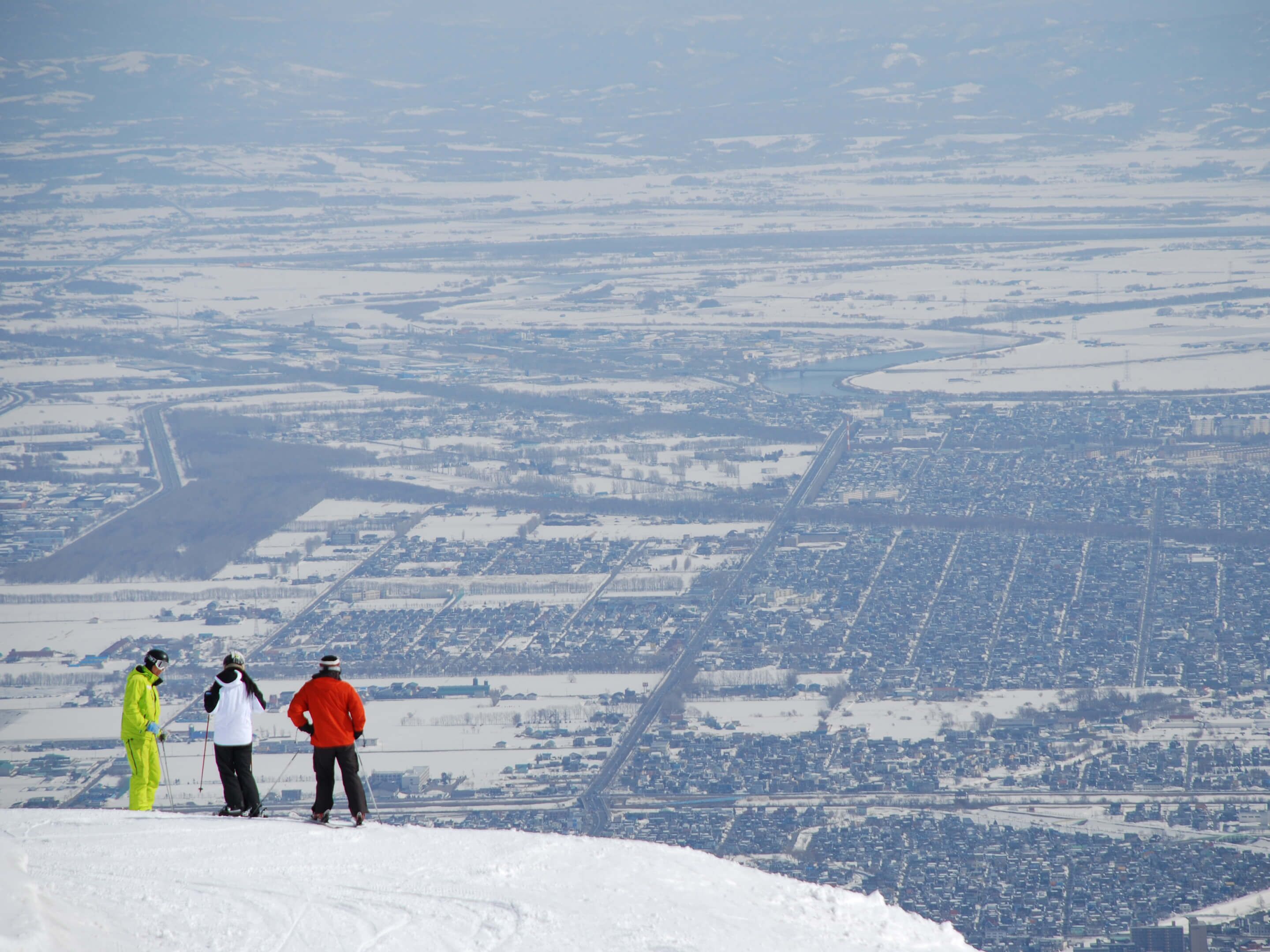 A snowy landscape with a bridge and a town below.