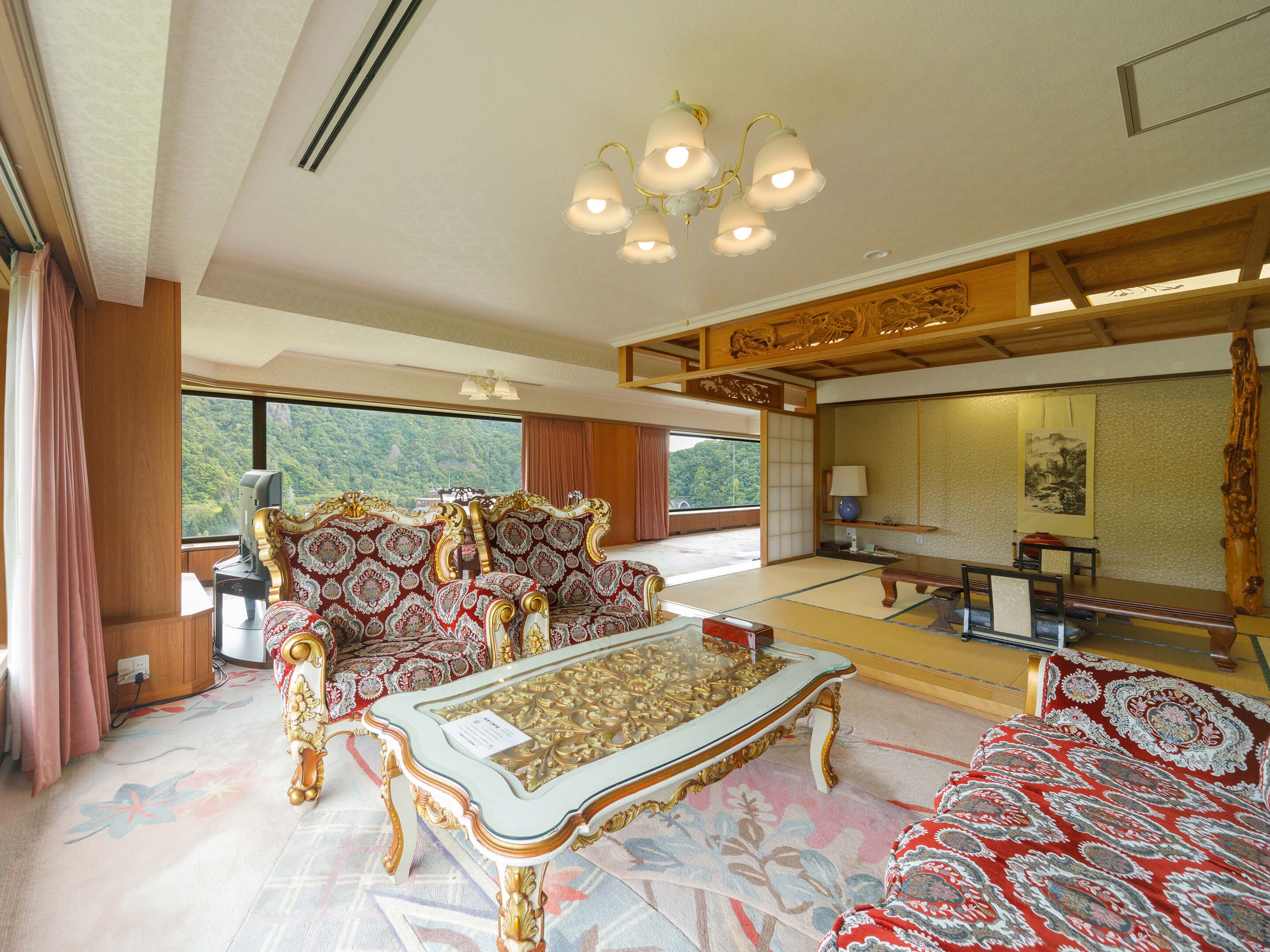 A traditional Japanese-style room with tatami flooring, a low table, and a sofa with intricate patterns.