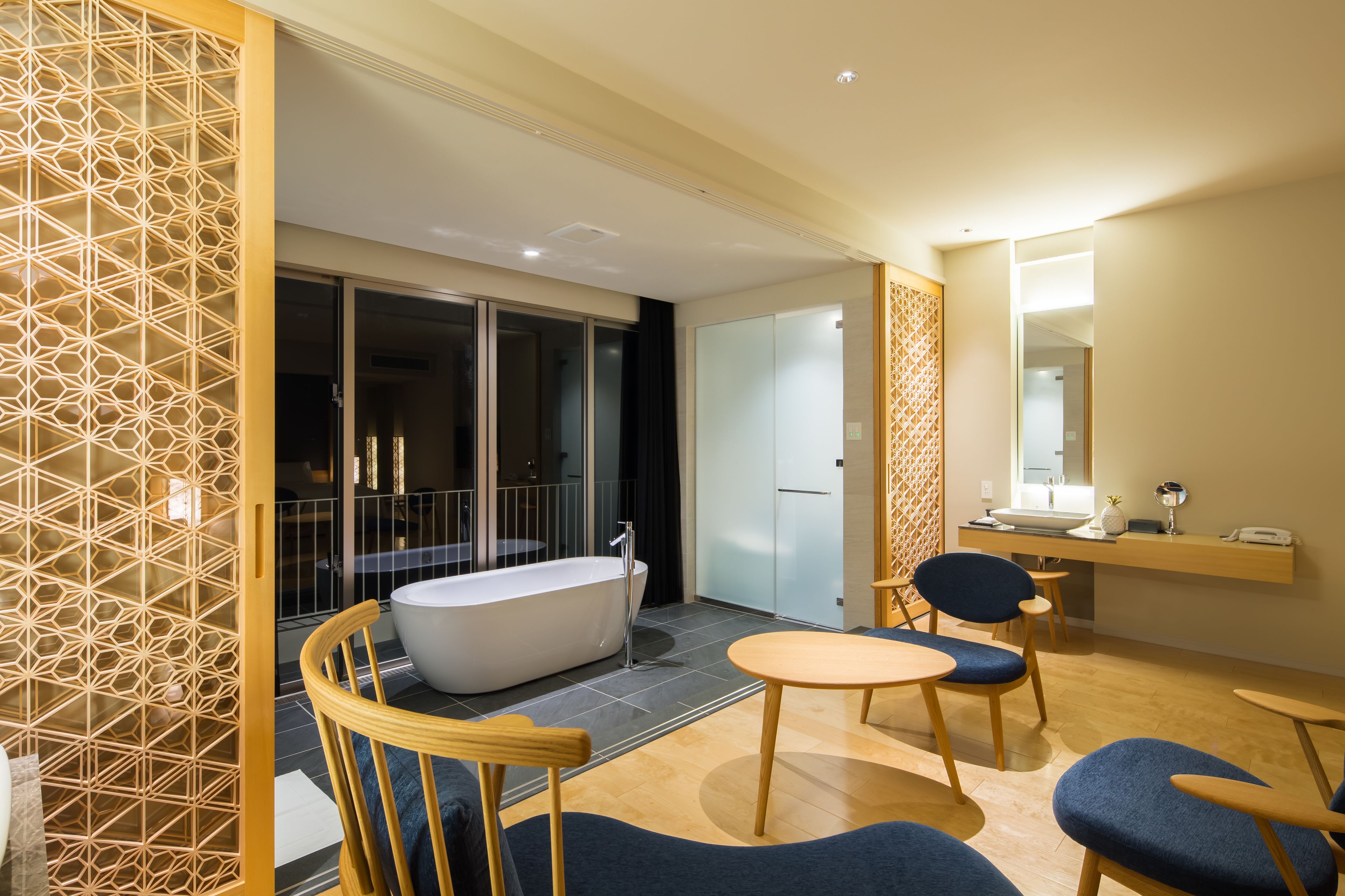 A modern bathroom with a freestanding bathtub, a glass-enclosed shower, and a vanity with a mirror and countertop.