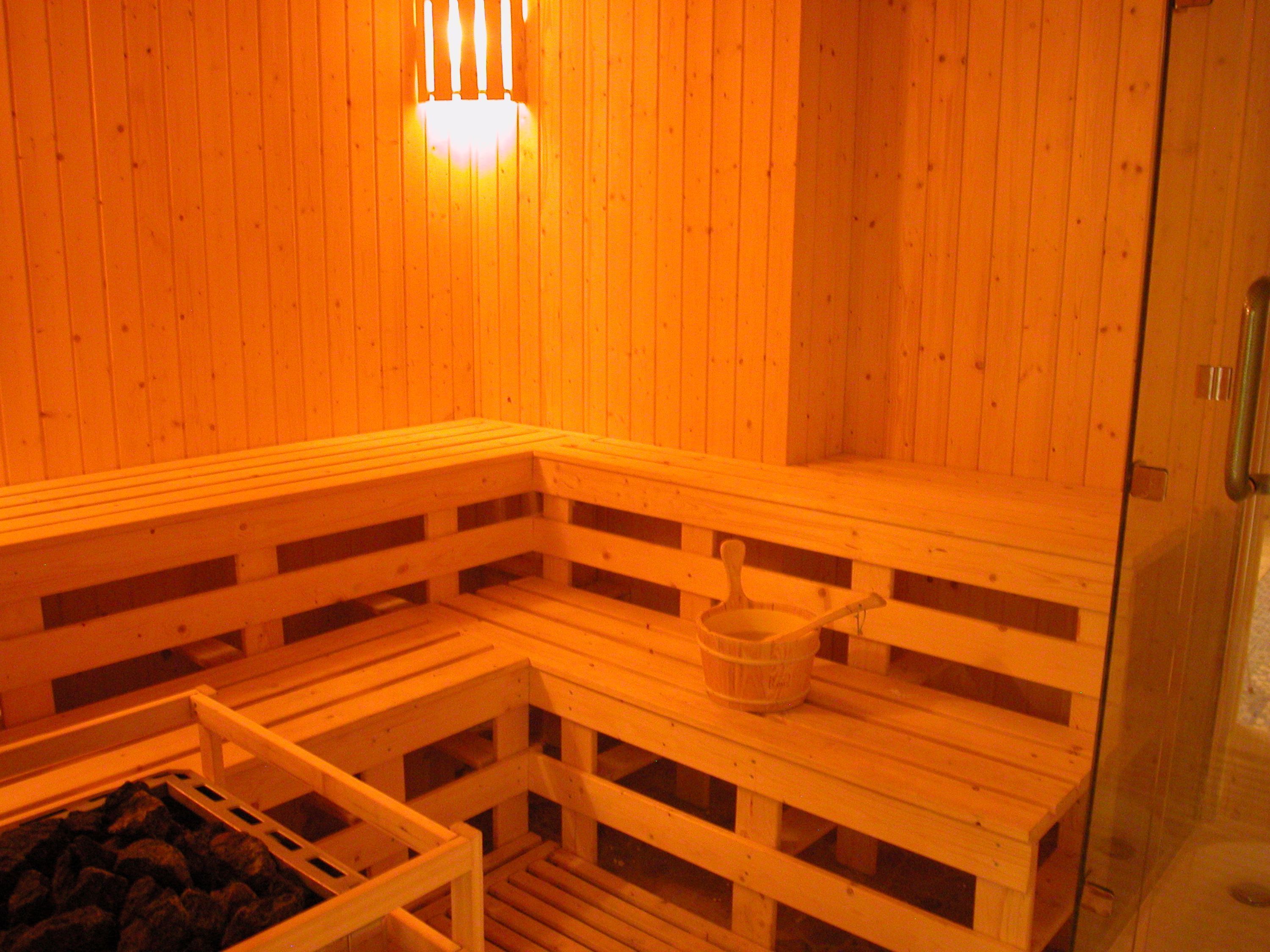 Un sauna avec des bancs en bois et une petite table sur laquelle se trouve un seau.