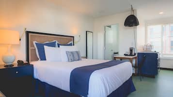 Relax in comfort with a large bed, bedside table, and desk with a chair.