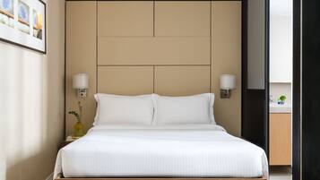 Een moderne hotelkamer met een groot bed, twee bedlampen, een hoofdbord en een klein nachtkastje met een vaas.