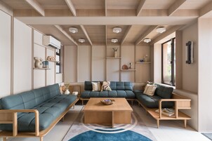 Una sala moderna con un sofá modular, una mesa de centro y estanterías empotradas.