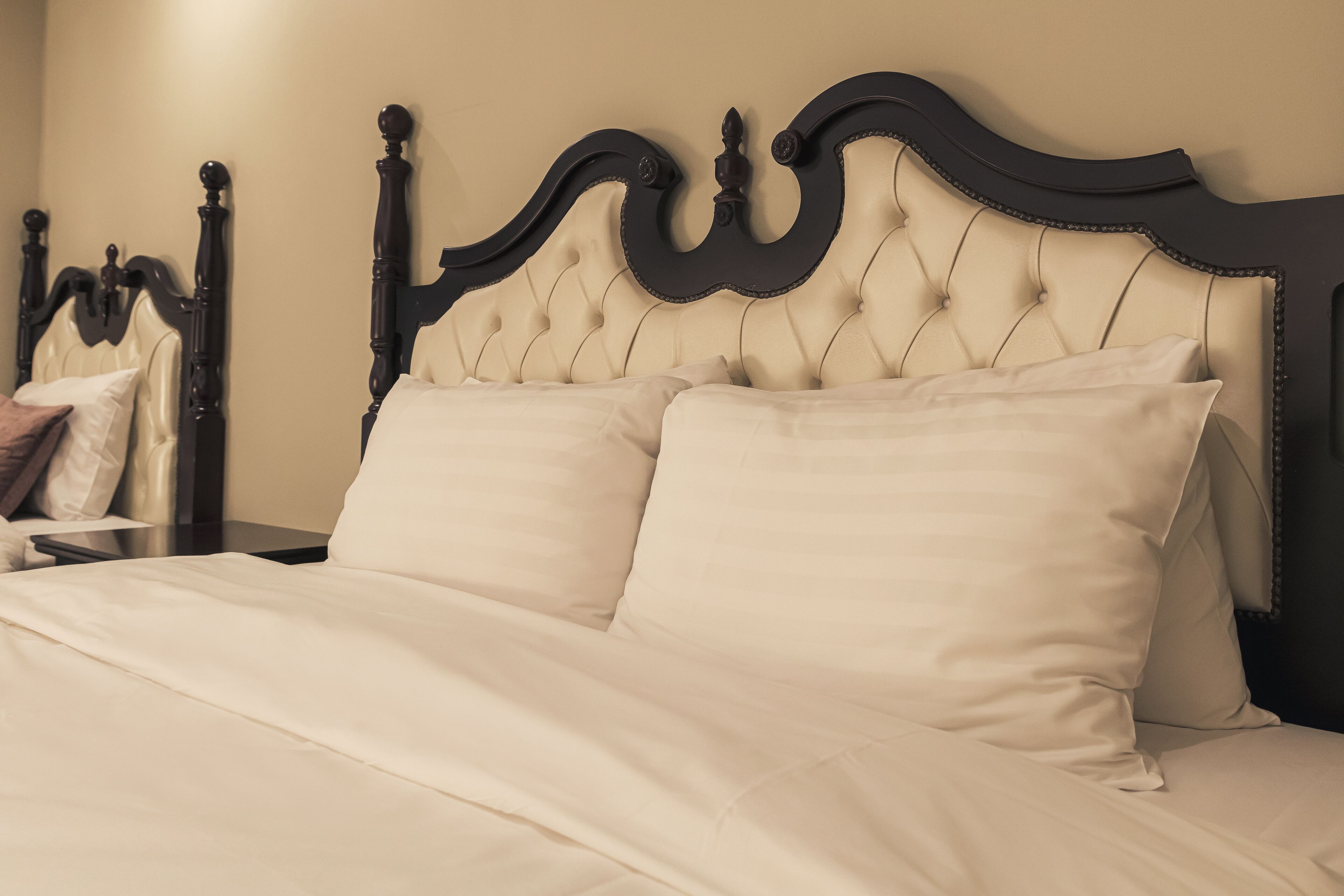 A bed with a tufted headboard and two pillows.