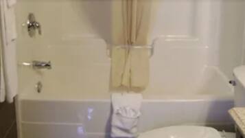 Une salle de bain avec une baignoire, des toilettes et un espace douche.
