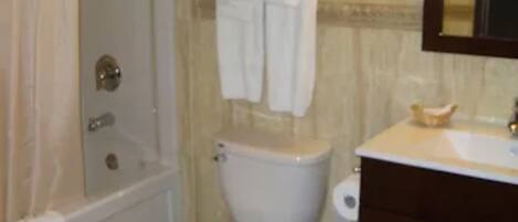 A bathroom with a shower, toilet, and sink.