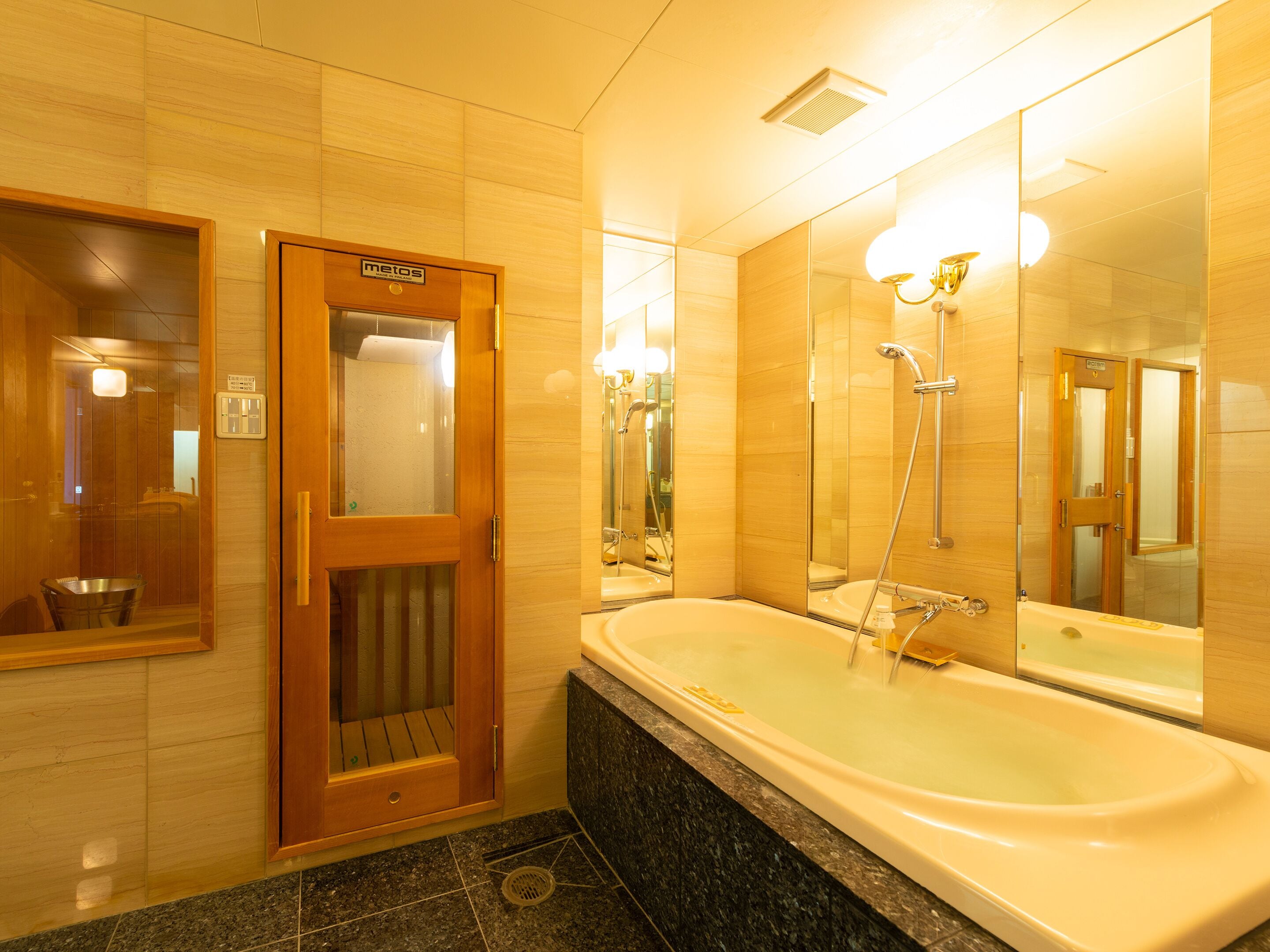 A bathroom with a wooden door, a bathtub, a shower, and a mirror.